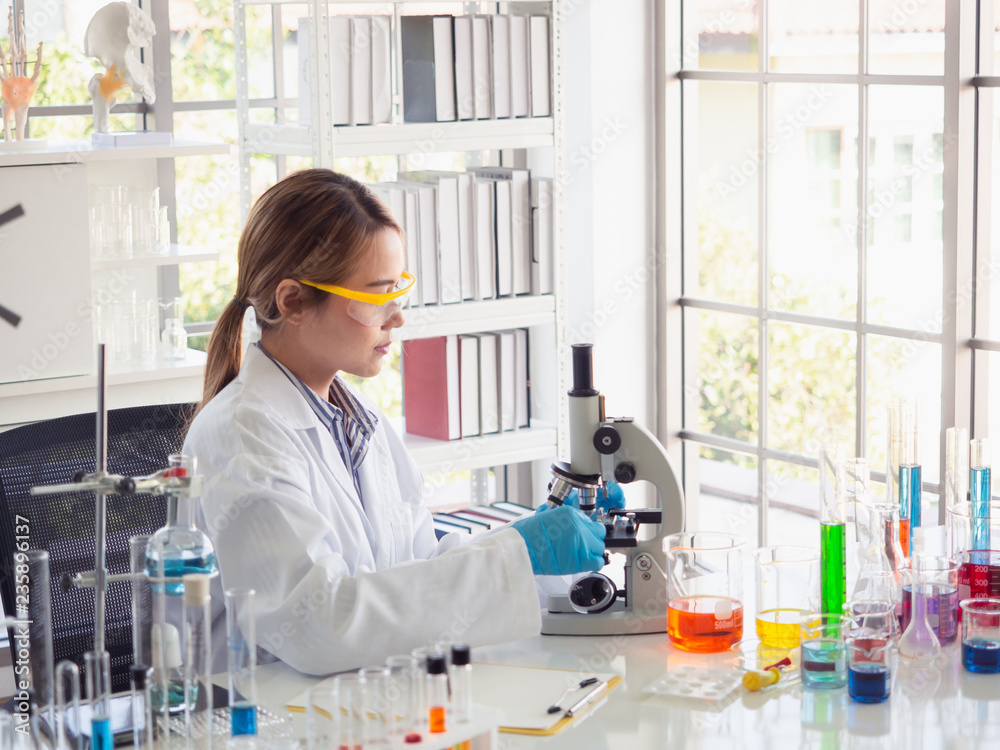 Fototapeta premium asian scientist working in laboratory with microscope