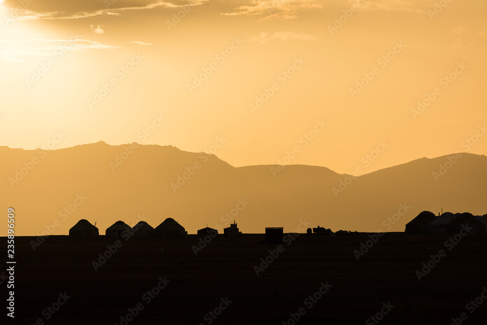 Silhouette of a yurt settlement at Song Kul lake in Kyrgyzstan at sunset