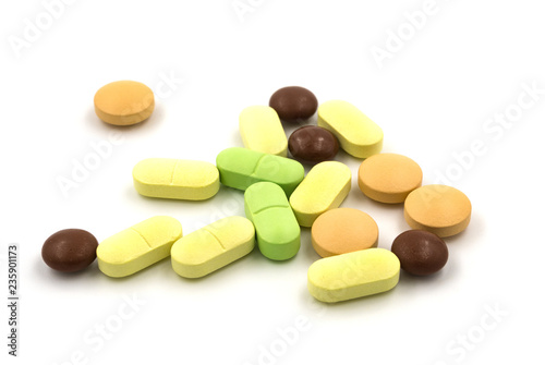 Multicolored tablets and pills on a white background