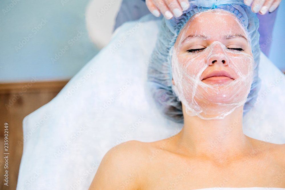 Young pretty woman enjoying a facial mask procedure