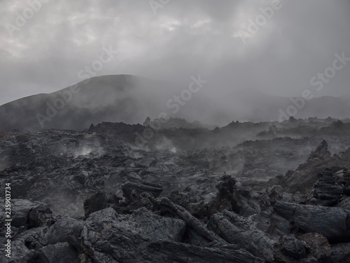 dark place. steam rises above the cooling lava flow of Tolbachik volcano
