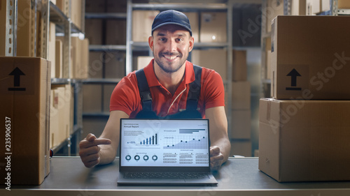 Happy Worker Shows Thumbs Up and Laptop Screen with Infographics Displaying Graph and Statistics with Annual Results Growth.  © Gorodenkoff