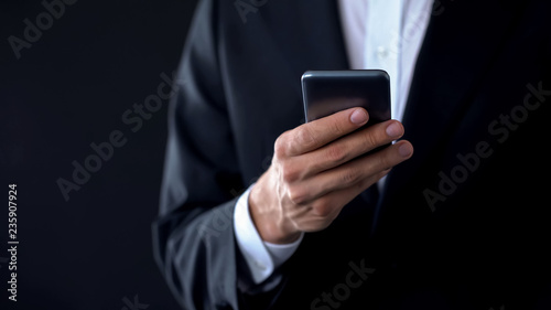 Businessman checking meeting calendar online, texting message on smartphone