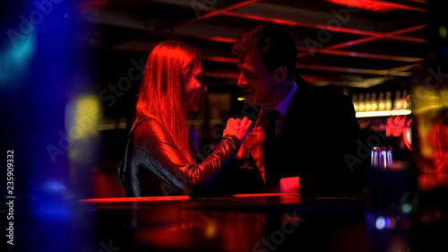 Happy beautiful couple drinking cocktails and flirting in nightclub, romance 