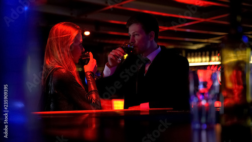 Couple drinking wine, man speaking to lady, capturing attention, pickup in club