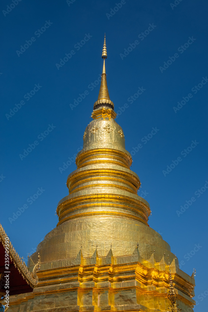 Fototapeta premium Wat Phra That Hariphunchai The province Lampoon of Thailand. There is a statue of Kruba Srichai in the temple.The temple has a golden pagoda. And green lawns. And the beautiful temple gazebo.
