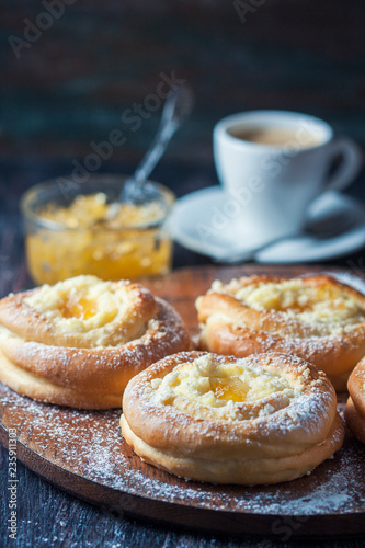 Homemade buns with ricotta and jam on a baking sheet. © Gulsina