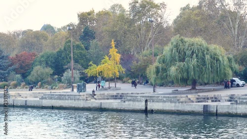 View on the quays in Paris (Seine river) in the jussieu disctrict. People are walking around. Autumn trees. Filmed in november. photo