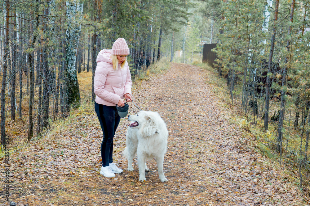 A pretty woman is walking her dog A pretty woman is walking her dog