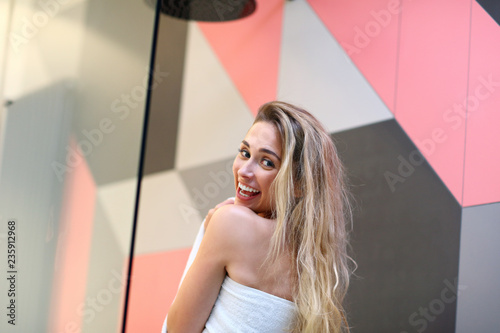 Beautiful blonde Caucasian woman posing in bathroom with wet hair