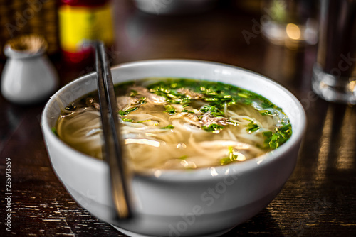 Pho Bo - Vietnamese fresh rice noodle soup with chicken, herbs and chili. Vietnam's national dish.