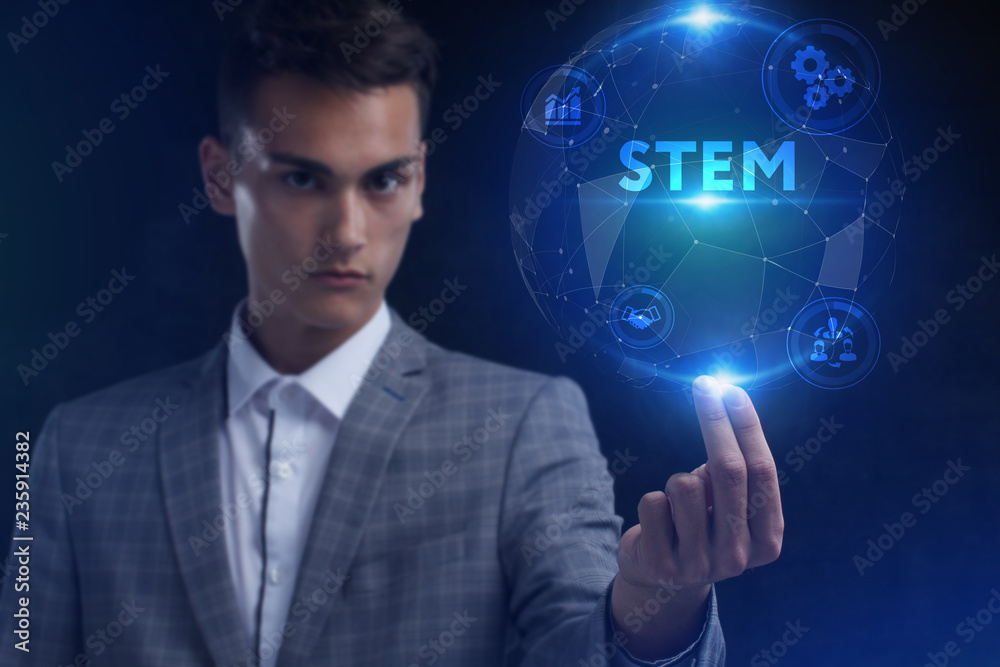 The concept of business, technology, the Internet and the network. A young entrepreneur working on a virtual screen of the future and sees the inscription: STEM The concept of business, technology, the Internet and the network. A young entrepreneur working on a virtual screen of the future and sees the inscription: STEM