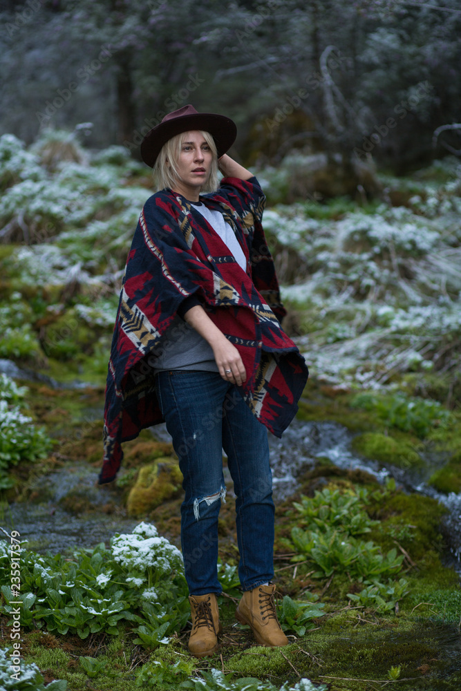 Stylish hipster girl in hat in autumn forest. Traveler woman exploring woods. Travel and adventure concept. Expedition vacation, space for text Stylish hipster girl in hat in autumn forest. Traveler woman exploring woods. Travel and adventure concept. Expedition vacation, space for text