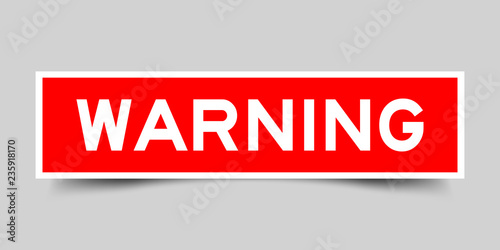 Square red sticker label in word warning on gray background