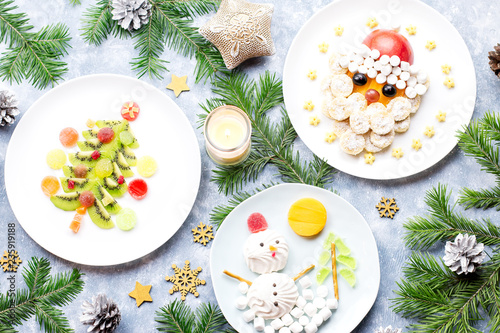 Christmas food for children - kiwi Christmas tree, marshmallow snowman, banana Santa Claus. Top view
