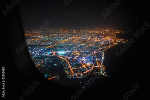 Aerial view of Sharjah from airplane window at night, United Arab Emirates