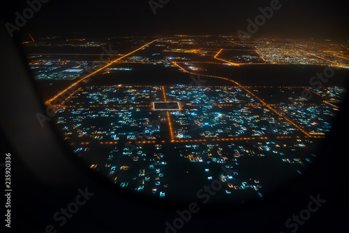 Fototapeta Naklejka Na Ścianę i Meble -  Aerial view of Sharjah from airplane window at night, United Arab Emirates