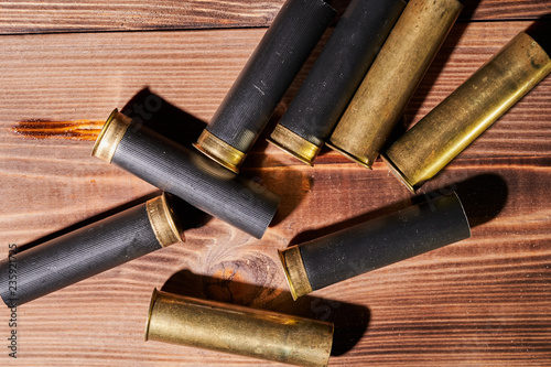 Hunting shells and 12 gauge cartridges on wooden background