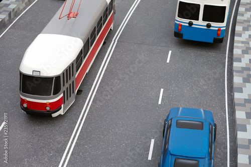 road traffic miniature with toy models of a modern tram, trolley bus and car