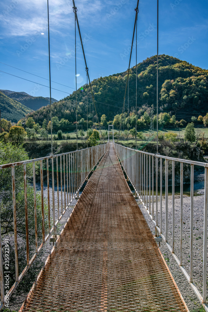 Obraz premium Cable-stayed old bridge over mountain river