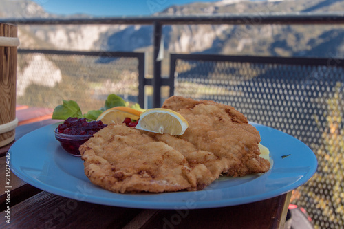 Schnitzel - Comida típica servida com a paisagem do lago Hallstatt ao fundo photo