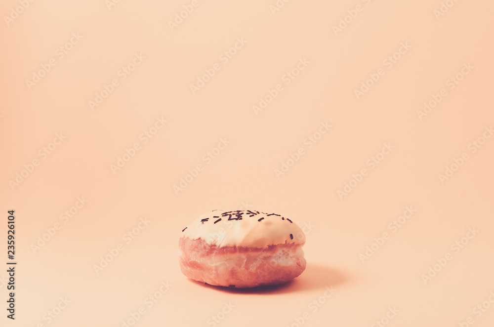 donut isolated on pink background/Donut in glaze decorated with dark chocolate sticks on pink background donut isolated on pink background/Donut in glaze decorated with dark chocolate sticks on pink background