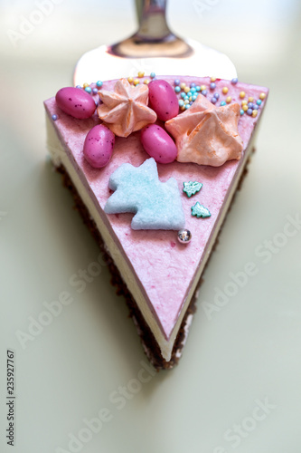 homemade cake decorated with edible Christmas trees and sweets on a bright mirror background