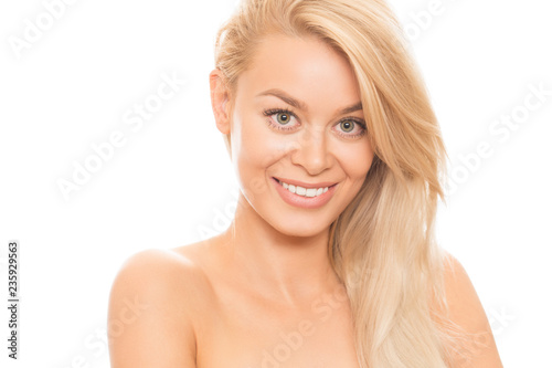 Happy healthy young gorgeous blonde woman with flawless shiny smooth skin and long strong hair smiling cheerfully to the camera isolated on white skincare face facial spa treatment cosmetology beauty