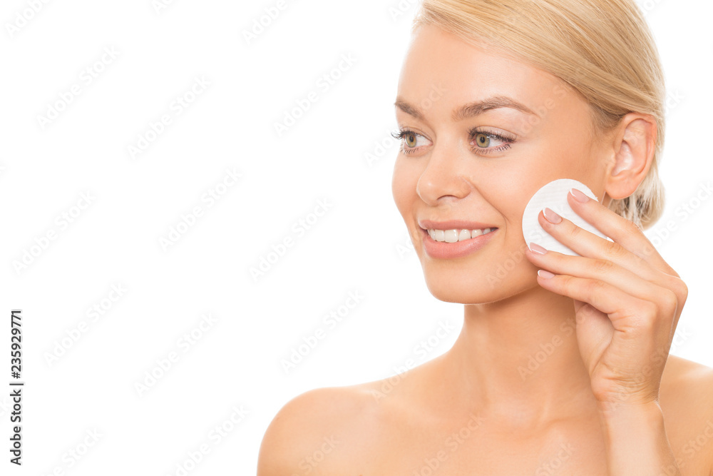 Close up of a beautiful young woman with healthy shiny smooth skin smiling looking away while cleansing her face with a cotton pad isolated copyspace positivity harmony beauty cosmetics cosmetology Close up of a beautiful young woman with healthy shiny smooth skin smiling looking away while cleansing her face with a cotton pad isolated copyspace positivity harmony beauty cosmetics cosmetology