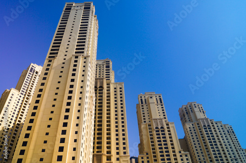 Skyscrapers from below in Dubai against blue sky. Raising the bar.