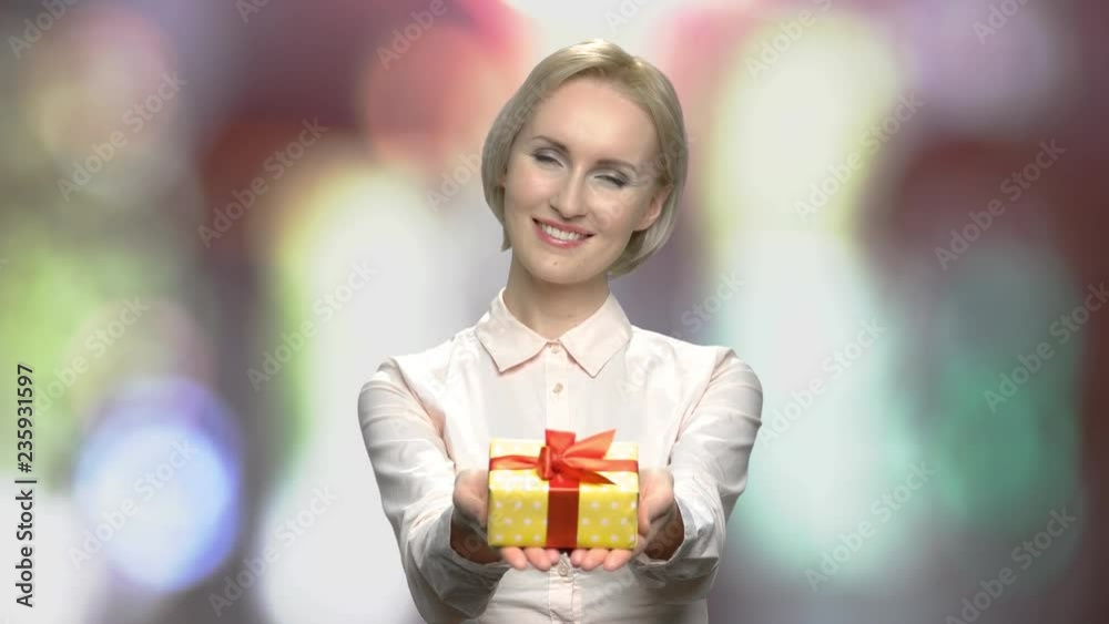 Pretty girl handing gift box to camera. Beautiful office woman giving gift box. Holiday gift concept. Pretty girl handing gift box to camera. Beautiful office woman giving gift box. Holiday gift concept.