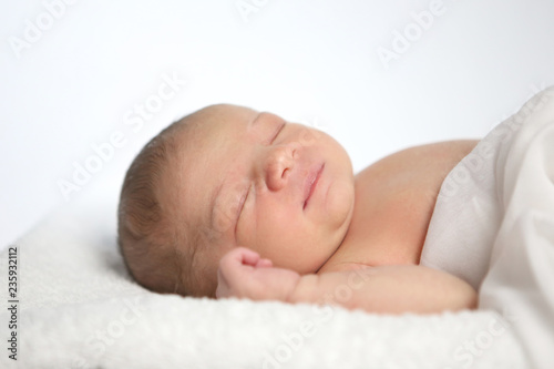 Schlafendes Neugeborenes liegt auf einem Fell