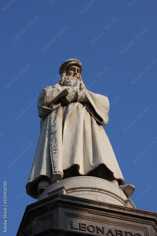 Monument to Leonardo Da Vinci with details around his statue on Piazza Della Scala in Milan, Italy.