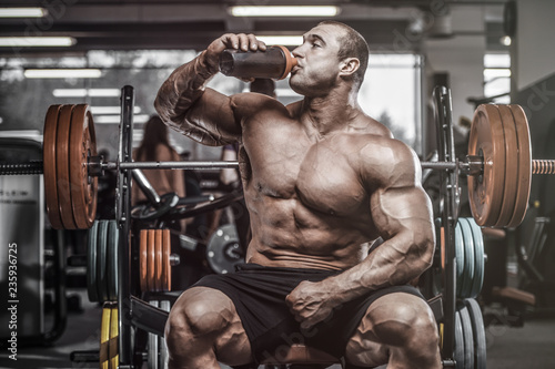 Brutal strong bodybuilder athletic men pumping up muscles with dumbbells