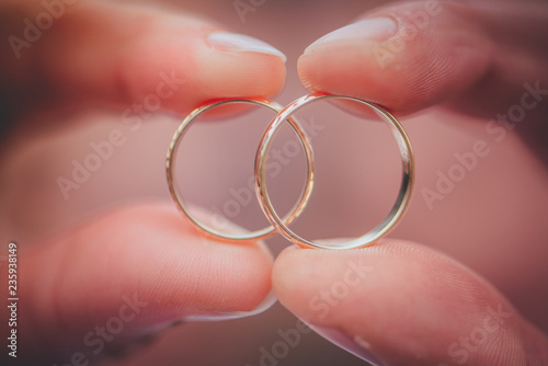 Wedding rings in hands of bride and groom, detail photo