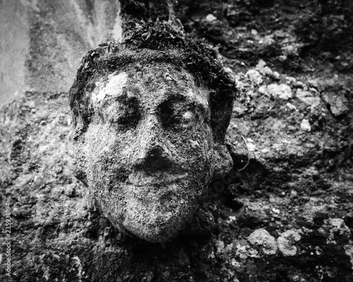 stone carving of a smiling man in black and white