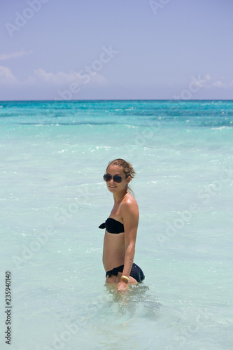 Junge sportliche Frau steht im Wasser in der Karibik