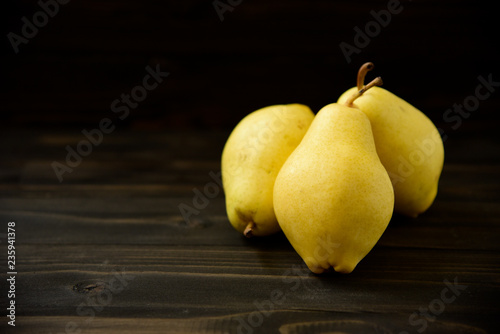 Yellow ripe fresh pears on old wooden board