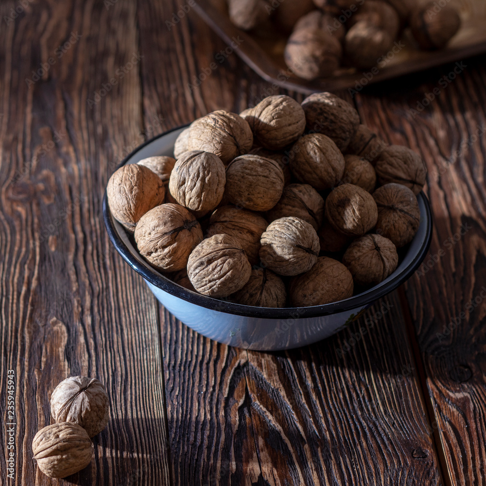 Walnuts in a blue plate on a wooden table
