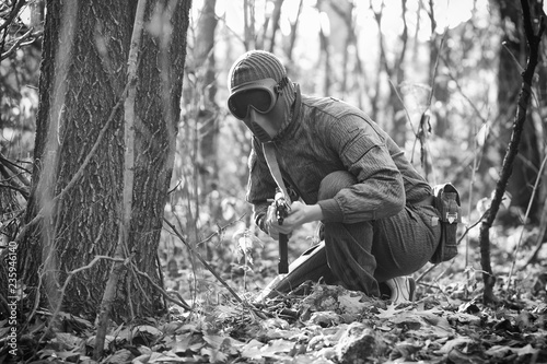 Soldier hides face. Soldier in the forest with machine gun. Black and White photography. 
