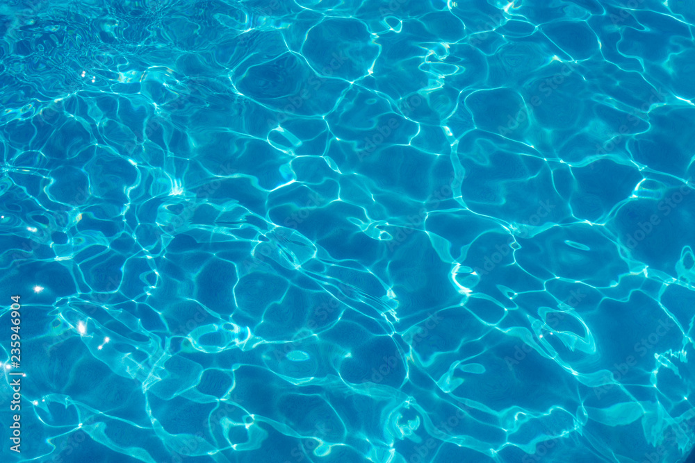 Water ripples and pattern on swimming pool surface with sunlight reflection