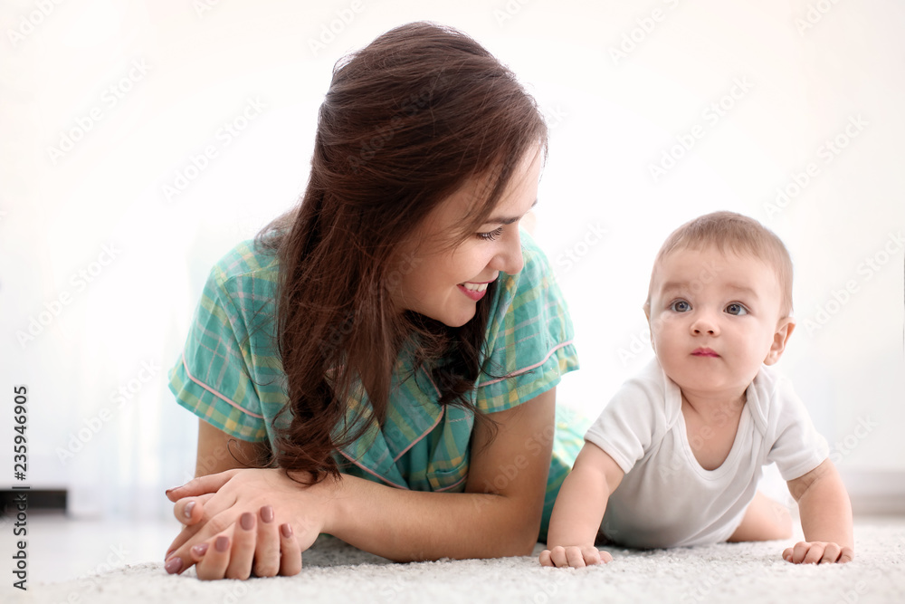 Loving mother and her baby lying on floor at home Loving mother and her baby lying on floor at home