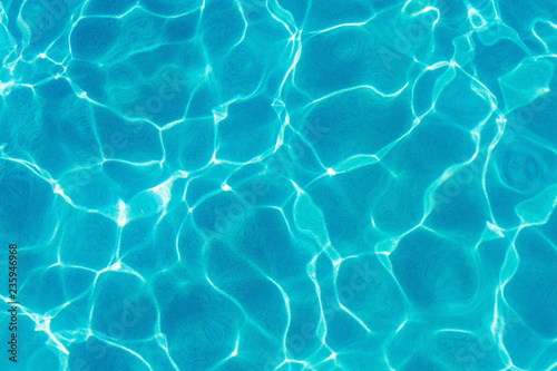 Water ripples and pattern on swimming pool surface with sunlight reflection