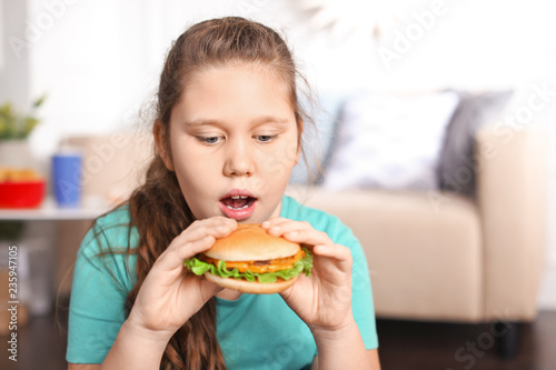 Overweight girl eating burg...