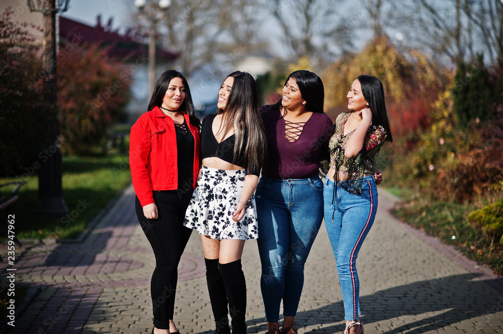 Obraz premium Group of four happy and pretty latino girls from Ecuador posed at street.