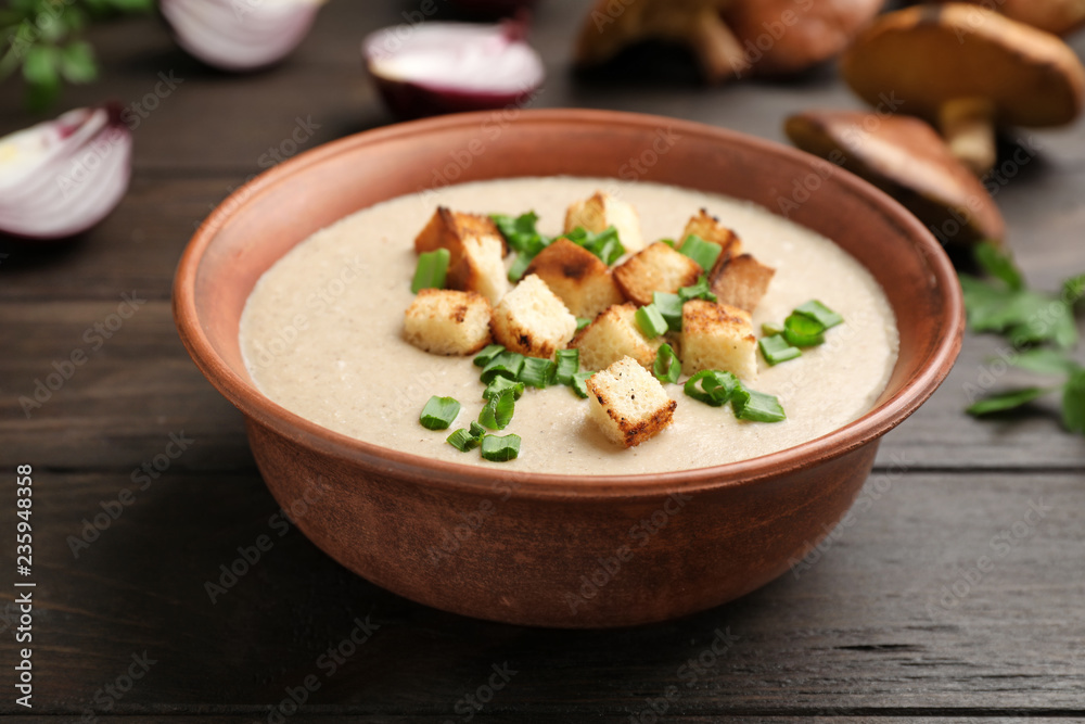 Bowl of fresh homemade mushroom soup on wooden table Bowl of fresh homemade mushroom soup on wooden table