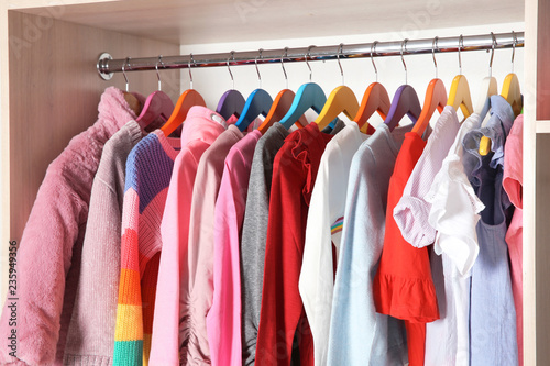 Wardrobe with stylish girl's clothes hanging on rack