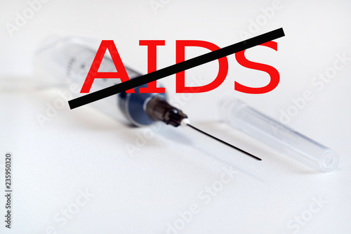 stop aids. No drugs. Syringe with needle on light background. The needle in the protective cap photo