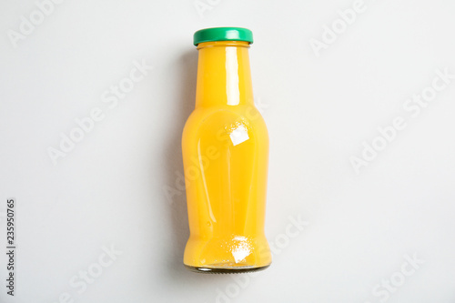 One bottle with tasty drink on color background, top view
