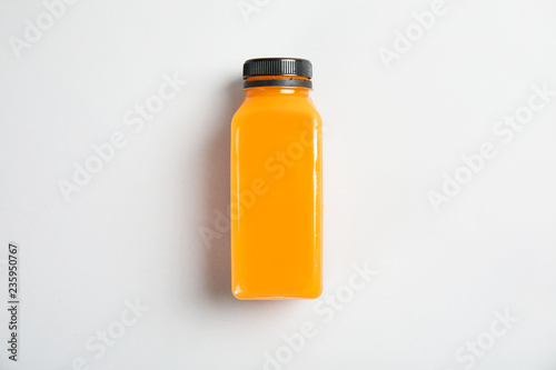 One bottle with tasty drink on color background, top view